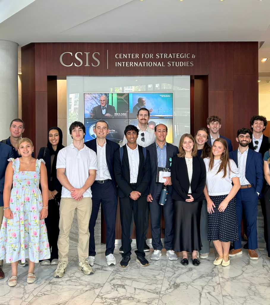 National security internship participants from national security policy center programs pose for a group photo in the marble lobby of CSIS