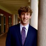 Headshot of Phillip Johnson in a suit and tie standing on UVA's grounds