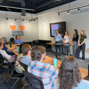 national security interns present research to an audience of NSDPI staff and national security professionals