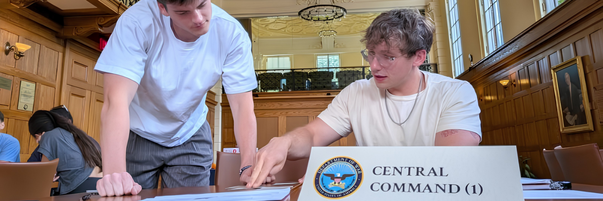 Two UVA students huddle together to discuss the details of a crisis simulation
