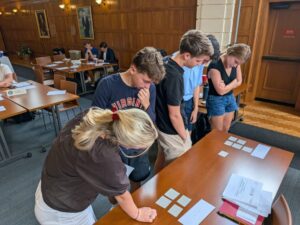 Four students stand at a table, working together as part of a crisis simulation